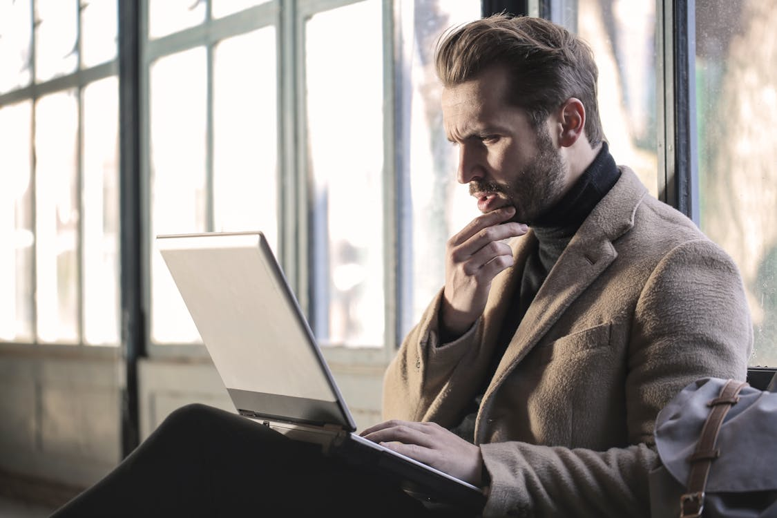 Person reviewing their policy on a laptop with a stressed expression